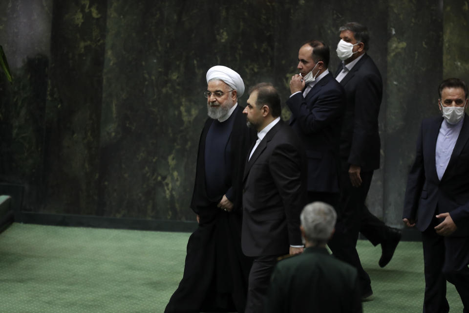 Iranian President Hassan Rouhani, left, arrives for the inauguration of the new parliament, in Tehran, Iran, Wednesday, May, 27, 2020. Iran has convened its newly elected parliament, dominated by conservative lawmakers and under strict social distancing regulations, as the country struggles to curb the spread of coronavirus that has hit the nation hard. Iran is grappling with one of the deadliest outbreaks in the Middle East. (AP Photo/Vahid Salemi)