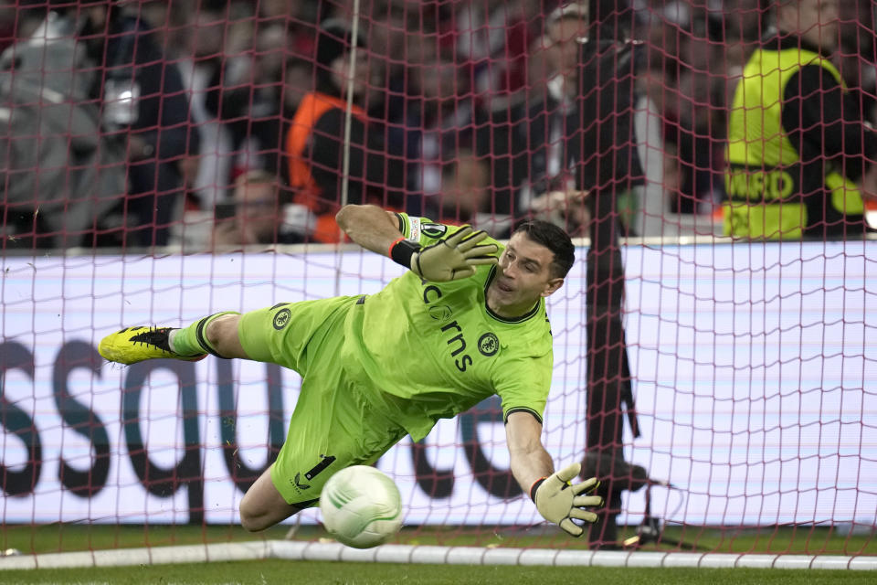 El arquero argentino Emiliano Martínez, del Aston Villa, ataja un penal en la vuelta de las semifinales de la Liga Europa ante Lille, el jueves 18 de abril de 2024 (AP Foto/Christophe Ena)