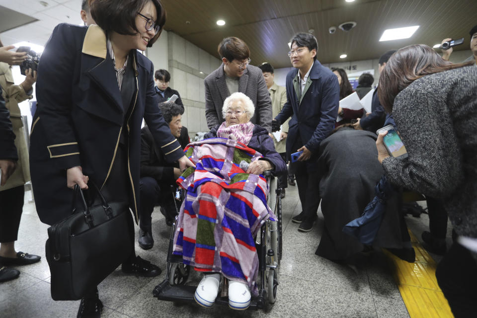 Former South Korean comfort woman Lee Ok-seon, center, leaves the Seoul Central District Court in Seoul, South Korea, Wednesday, Nov. 13, 2019. A Seoul court on Wednesday began hearing a long-awaited civil case filed against the Japanese government by South Korean women who were forced to work in Japan's World War II military brothels. (AP Photo/Ahn Young-joon)