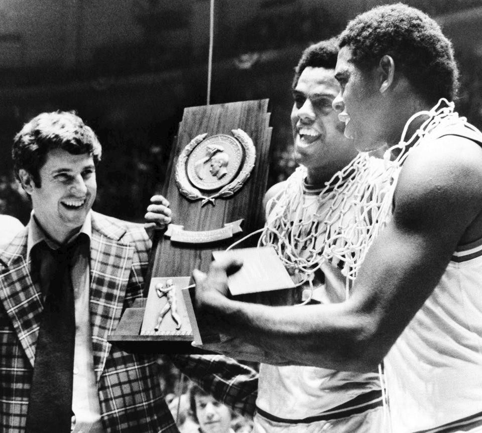 FILE - Indiana coach Bob Knight, left, and players Scott May, center, and Quinn Buckner, right, hold the trophy after the team's win in the NCAA men's college basketball tournament in Philadelphia on March 29, 1976. Knight, the brilliant and combustible coach who won three NCAA titles at Indiana and for years was the scowling face of college basketball, has died. He was 83. Knight's family made the announcement on social media on Wednesday night, Nov. 1, 2023, saying he was surrounded by family members at his home in Bloomington, Ind. (AP Photo/File)