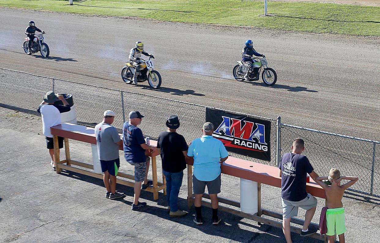 Spectators watch the motorcycles race on the Ashland County Fairgrounds race track during the AMA Vintage Motorcyle races Saturday, July 23, 2022. TOM E. PUSKAR/ASHLAND TIMES-GAZETTE