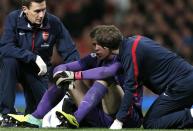 Arsenal medics talk with Wojciech Szczesny (C) after a clash of heads with Manchester United's Phil Jones during their English Premier League soccer match at Old Trafford in Manchester, northern England, November 10, 2013.