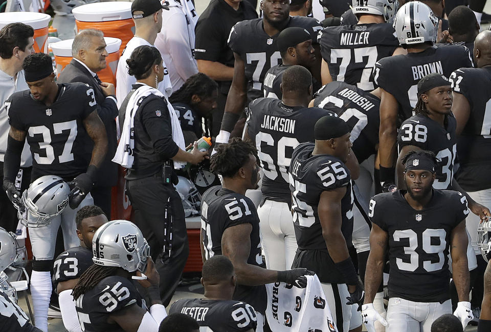 Oakland Raiders running back Marshawn Lynch, center left, sits near the sideline just before the national anthem at an NFL preseason football game between the Raiders and the Detroit Lions in Oakland, Calif., Friday, Aug. 10, 2018. Lynch remained seated for the anthem. (AP Photo/Jeff Chiu)