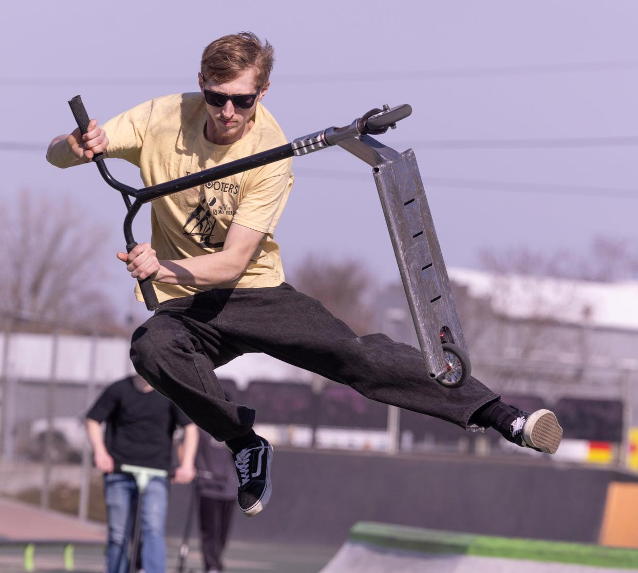 Drew Whittington of Cleveland does a bri flip on his scooter at the 9th Street DIY skate park in Canton.