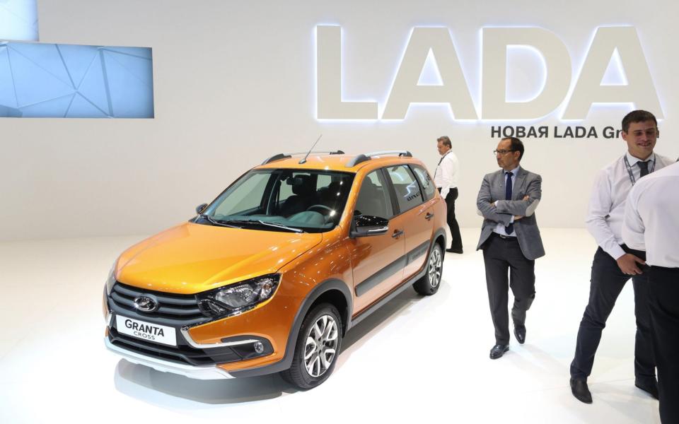 Visitors look at a Lada Granta Cross automobile, manufactured by OAO AvtoVAZ at the Russia International Auto Show in August. - Bloomberg