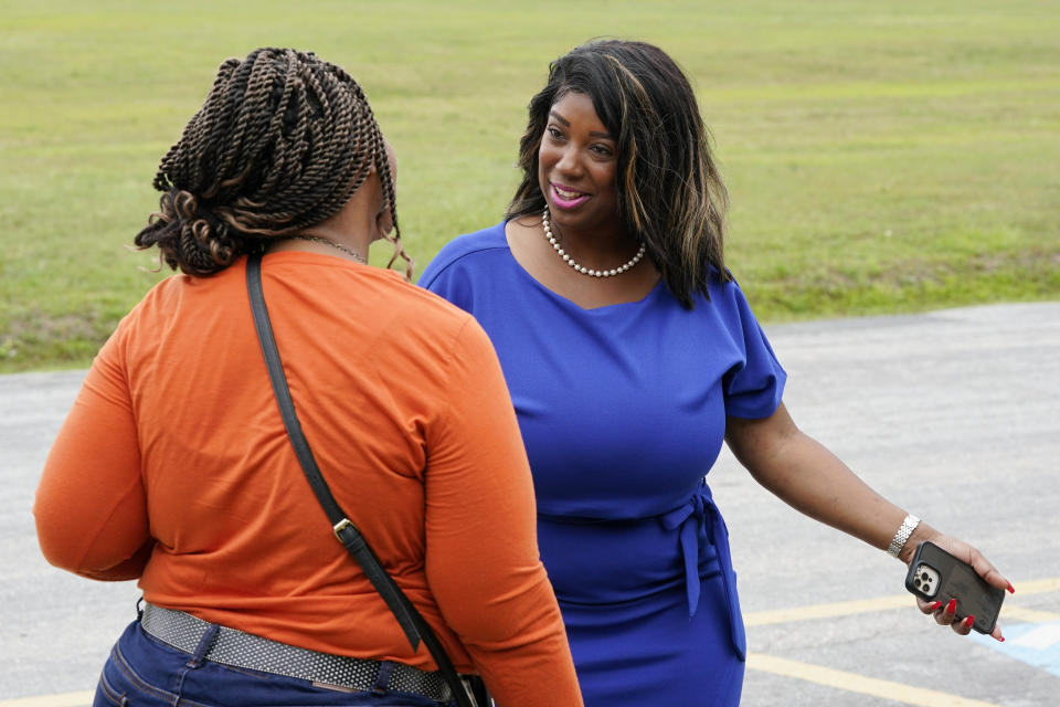 Former Virginia State Delegate Lashrecse Aird, right, talks with a voter as she visits a polling precinct Tuesday, June 20, 2023, in Surry, Va. Aird is running against Virginia State Sen. Joe Morrissey in a Democratic primary for a newly redrawn Senate district. (AP Photo/Steve Helber)