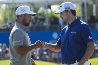 Patrick Cantlay, right, congratulates teammate Xander Schauffele after they finished on the 18th green during the third round of the PGA Zurich Classic golf tournament at TPC Louisiana in Avondale, La., Saturday, April 22, 2023. (AP Photo/Gerald Herbert)
