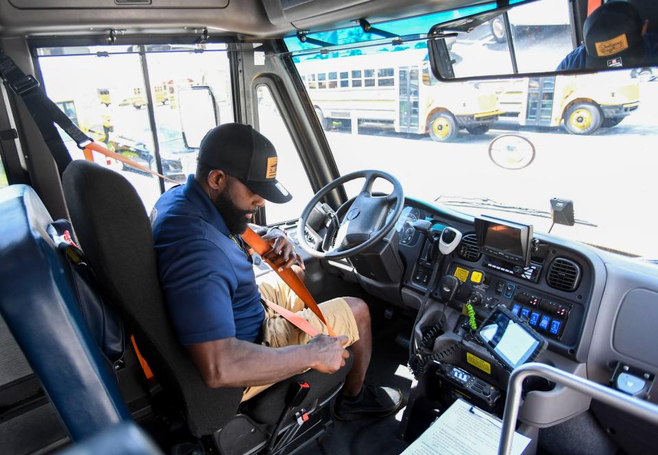 St. Lucie County bus driver, Michael Brown, demonstrates his role on his school bus, Wednesday, Oct. 18, 2023, at the St. Lucie County school board bus compound. "Attitude is everything," Brown said. "I'm the first person that they see, so I want that to be a moment to see that smiling face. I think that helps them go through their day. We don't know what they go through when they're not with us, so it's important."