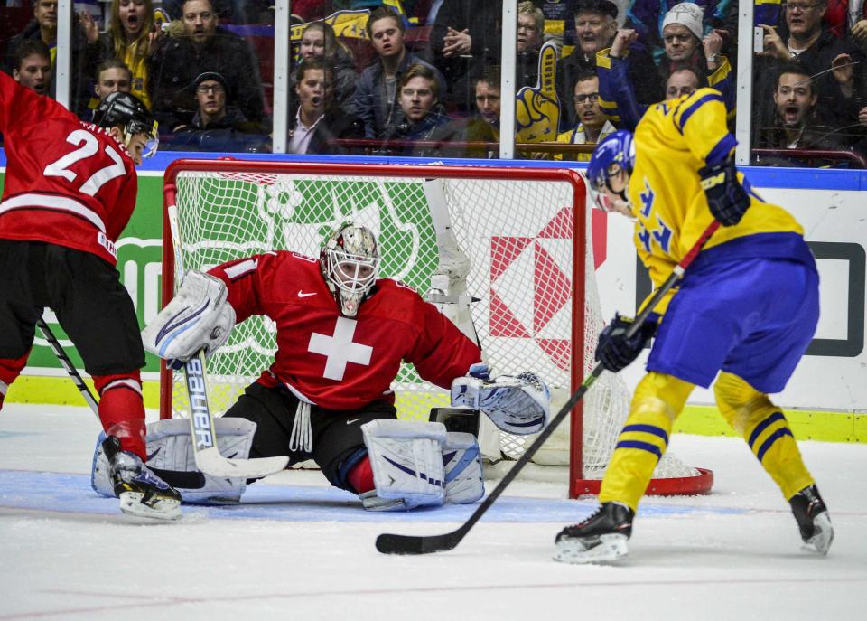 Switzerland's goalie Nyffeler tries to save a shot from Sweden's Sundqvist during the first period of their IIHF World Junior Hockey Championship ice hockey game in Malmo