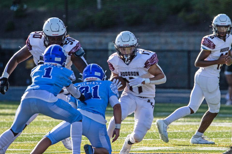 Hodgson's Jace Hawkins runs against Howard's DreShawn Anderson (1) and Miesh Echevarria on Aug. 31. All three of our experts believe Caravel will defeat Hodgson on Thursday night.