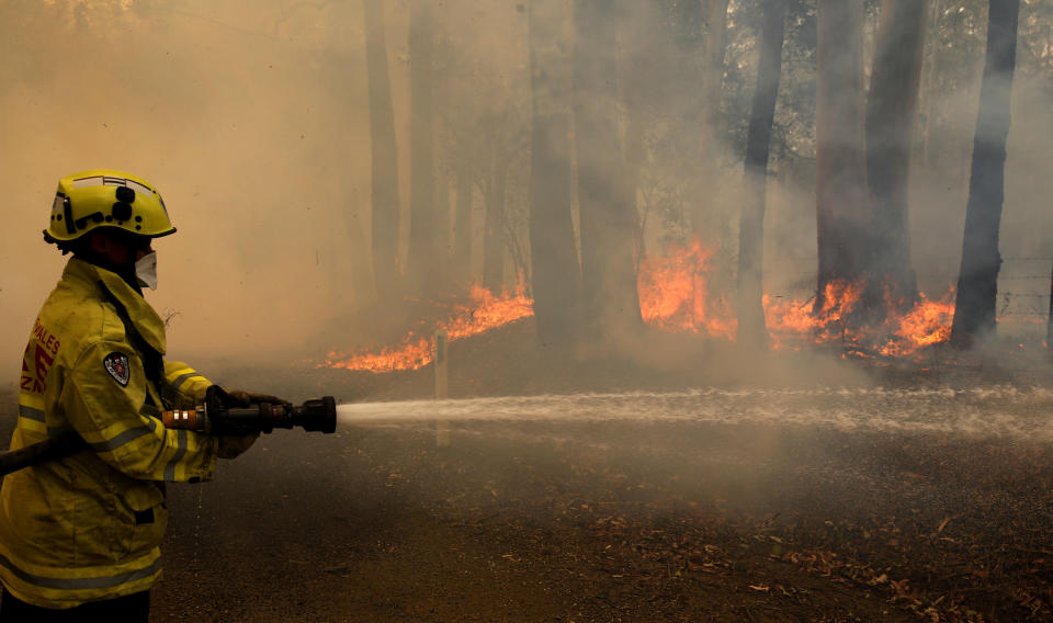 A Gloucester fire crew member fights flames at Koorainghat on Tuesday as the fires worsen across NSW.