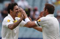 Australia's Mitchell Johnson (L) celebrates with Ryan Harris after taking the wicket of England's captain Alastair Cook during the fourth day's play in the second Ashes cricket test at the Adelaide Oval December 8, 2013.
