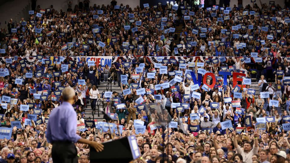 People hold signs as former President Barack Obama speaks during a campaign event in support of Vice President Kamala Harris in Pittsburgh on October 10, 2024. - Quinn Glabicki/Reuters