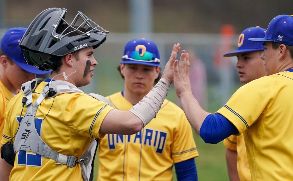 Ontario catcher Jake Chapman sports an ear piece connected to an electronic communication device that allows him to hear called pitches from a coach in the dugout.