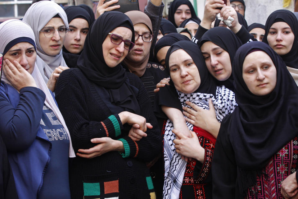 Palestinian women mourn during the funeral procession of two members of Hamas who were killed after gunfire erupted last Sunday during a Hamas-organized funeral in a tense Palestinian refugee camp, near the southern port city of Sidon, Lebanon, Tuesday, Dec. 14, 2021. (AP Photo/Mohammed Zaatari)