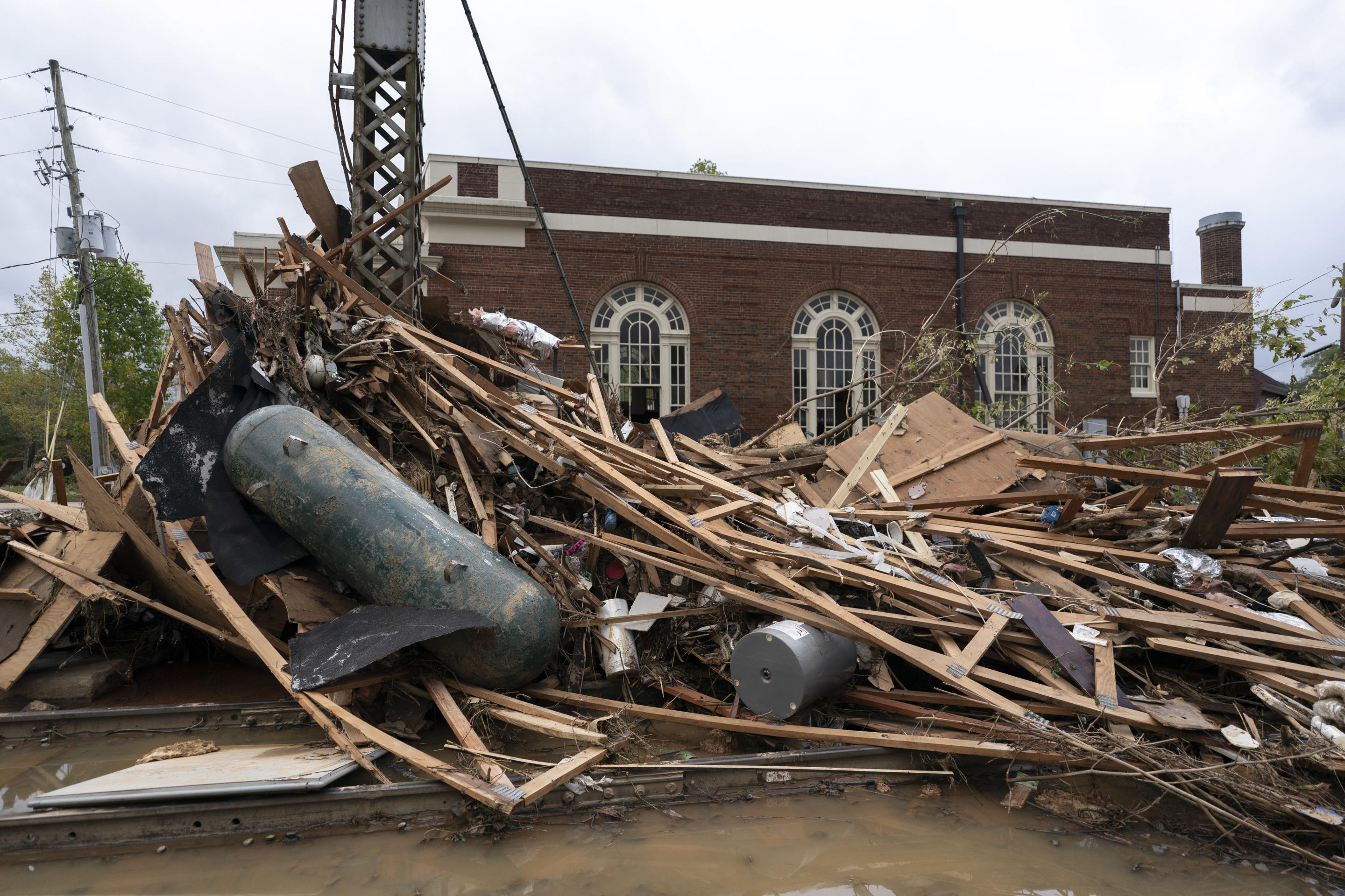 A huge pile of wooden slats, metal and other debris in the standing water.