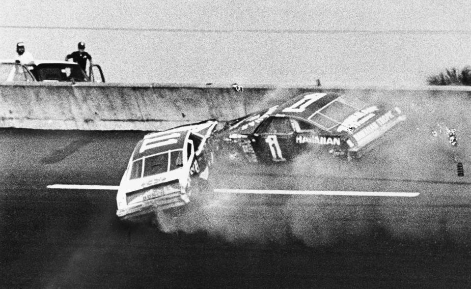 Donnie Allison (1) and Cale Yarborough (11) crash on the final lap of the 1979 Daytona 500, sending Richard Petty to Victory Lane. Allison and Yarborough famously fought after both climbed from their cars in front of a national television audience.