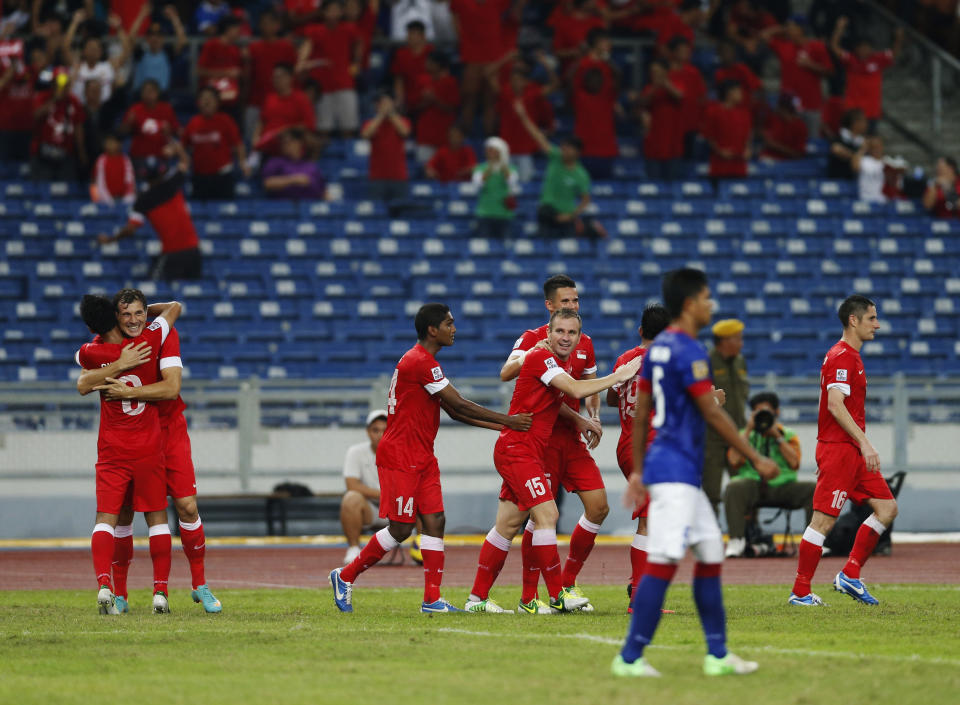 Singapore's football players (red jerseys) celebrate after their third goal against Malaysia in their AFF Suzuki Cup Group B soccer match in Kuala Lumpur on 25 November 2012. (PHOTO: Reuters/Bazuki Muhammad)