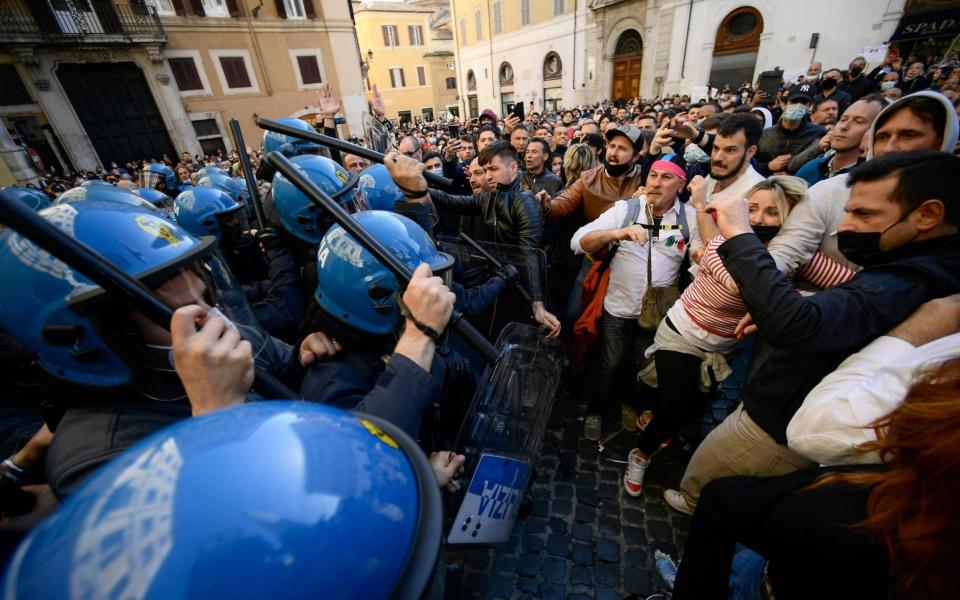 Anti-riot policemen use batons against protesters during skirmishes within a demonstration of restaurant owners, entrepreneurs and small businesses owners outside parliament on Piazza Montecitorio in Rome, against closures and against Italy's Health minister policy - Filippo MONTEFORTE / AFP