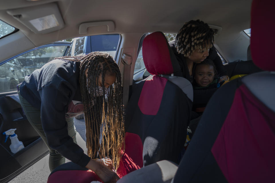Angelica Lyons secures her 2-year old son, Malik Lyons-Law, into his child car seat while her sister, Ansonia Lyons, prepares to ride with her after their breakfast outing to celebrate their father's birthday, Saturday, Feb. 5, 2022, in Birmingham, Ala. Both sisters delivered via C-sections. Cesarean delivery rates are higher for Black women than white women, 35.9% and 30.7%, respectively, in 2019. (AP Photo/Wong Maye-E)