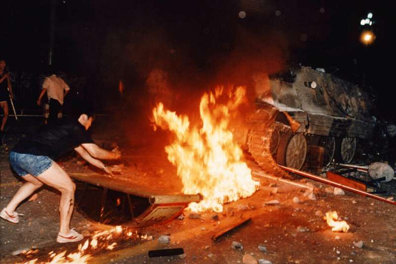 六四、1989年6月4日，北京街頭示威學生在燃燒的路障前試圖阻止坦克前進。（AP）