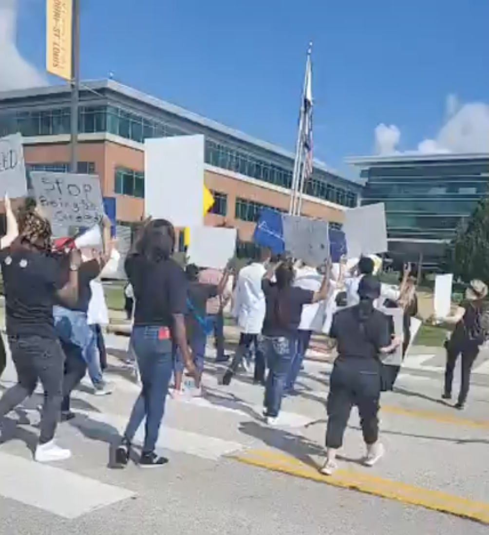 Dozens of protesters march in front of the St. Louis-headquarters of Express Scripts, one of the nation's largest pharmacy benefits managers, on Friday, May 17, 2024.