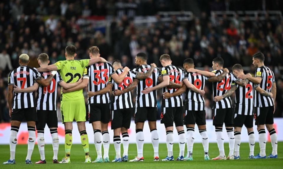 Newcastle players arm in arm during the playing of the Last Post for Remembrance Day ahead of kick-off in the English Premier League football match between Newcastle United and Arsenal at St James' Park in Newcastle-upon-Tyne, north east England on November 4, 2023. (Photo by Oli SCARFF / AFP) / RESTRICTED TO EDITORIAL USE. No use with unauthorized audio, video, data, fixture lists, club/league logos or 'live' services. Online in-match use limited to 120 images. An additional 40 images may be used in extra time. No video emulation. Social media in-match use limited to 120 images. An additional 40 images may be used in extra time. No use in betting publications, games or single club/league/player publications. /  (Photo by OLI SCARFF/AFP via Getty Images)