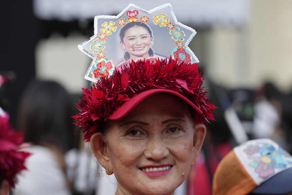 A supporter of Pheu Thai Party puts a picture of Paetongtarn Shinawatra, one of the party's three registered nominees for prime minister, on her head in Bangkok, Thailand, May 5, 2023. Voters disaffected by nine years of plodding rule by a coup-making army general are expected to deliver a strong mandate for change in Thailand's general election Sunday, May 14, 2023. (AP Photo/Sakchai Lalit)