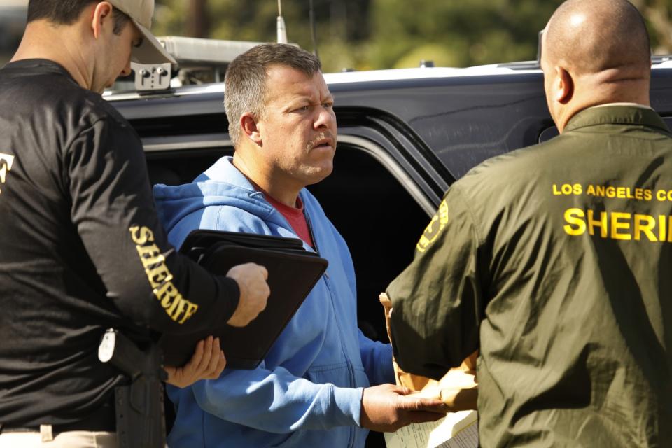 Paul Flores talks with deputies near their vehicle.