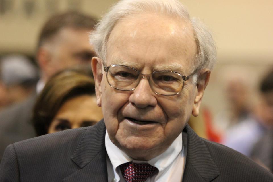 Warren Buffett surrounded by people at Berkshire Hathaway's annual shareholders meeting.