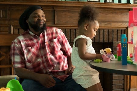 Monae Davis plays with a grandchild after an interview in Buffalo