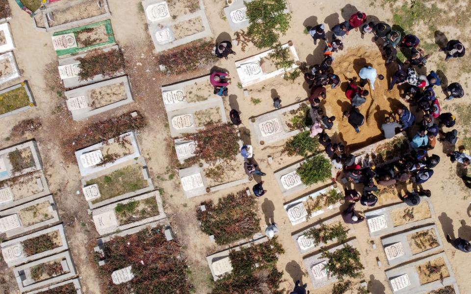 A picture taken with a drone shows Palestinians burying the body of a man, who died after contracting the coronavirus at a cemetery in the central Gaza Strip - REUTERS/Mohammed Salem