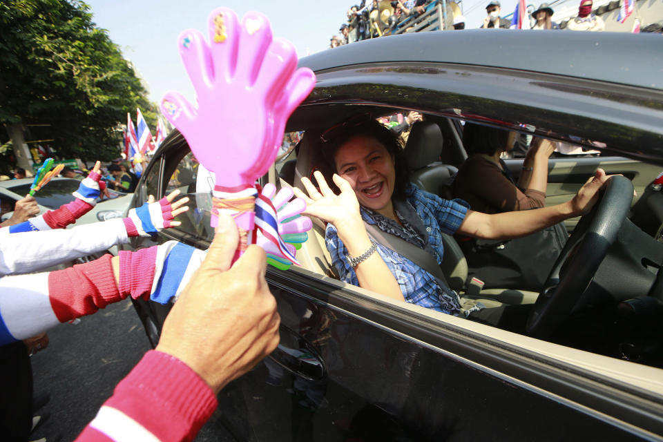 A woman cheers anti-government protesters make their way on a street during a rally Friday, Jan. 24, 2014 in Bangkok. Thailand’s Constitutional Court ruled Friday that nationwide elections scheduled for Feb. 2 can legally be delayed. (AP Photo/Wason Wanichakorn)