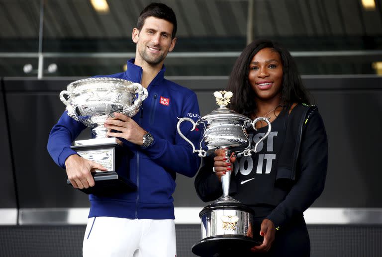 Novak Djokovic y el trofeo de campeón del Abierto de Australia que levantó en 9 oportunidades; aquí, junto a Serena Williams 