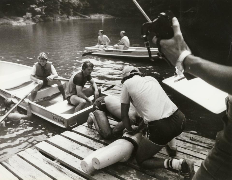 Boy Scouts Steve Blais (rowboat, left), Bruce Faris (rowboat, right), Mike Knapik (dock, left) and Abdel Hamid (dock, right) practice CPR on a lake dock at Camp Lazarus in Delaware, Ohio, in 1983.