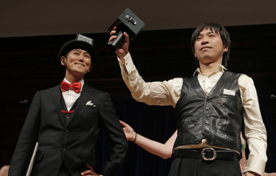 Japanese researchers Kazutaka Kurihara, left, and Koji Tsukada accept their award during a performance at the Ig Nobel Prize ceremony at Harvard University, in Cambridge, Mass., Thursday, Sept. 20, 2012. The Ig Nobel prize is an award handed out by the Annals of Improbable Research magazine for silly sounding scientific discoveries that often have surprisingly practical applications. (AP Photo/Charles Krupa)