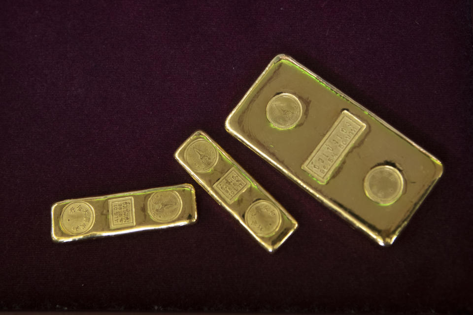 FILE - In this April 16, 2020, file photo, a customer puts gold bars on basket for sell to a gold shop in Bangkok, Thailand. The price of gold surged more than $30 on Monday, July 27, 2020 to over $1,926 per ounce as investors step up buying of the precious metal often sought in times of uncertainty. Gold was trading at $1,926.20 by early afternoon in Asia, up 1.5%, after surging over the weekend. (AP Photo/Sakchai Lalit, File)