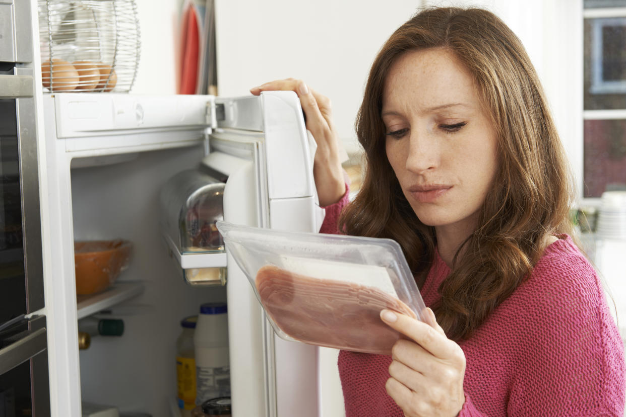 Concerned Woman Looking At Pre Packaged Meat