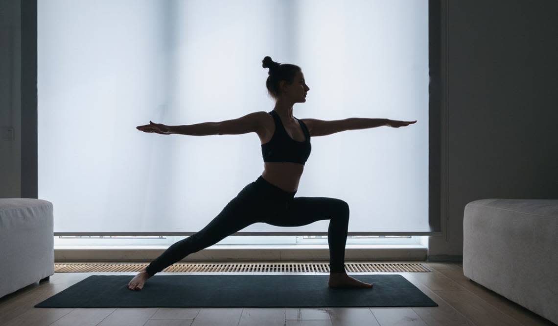 A stock image shows a woman in a warrior yoga pose. 
