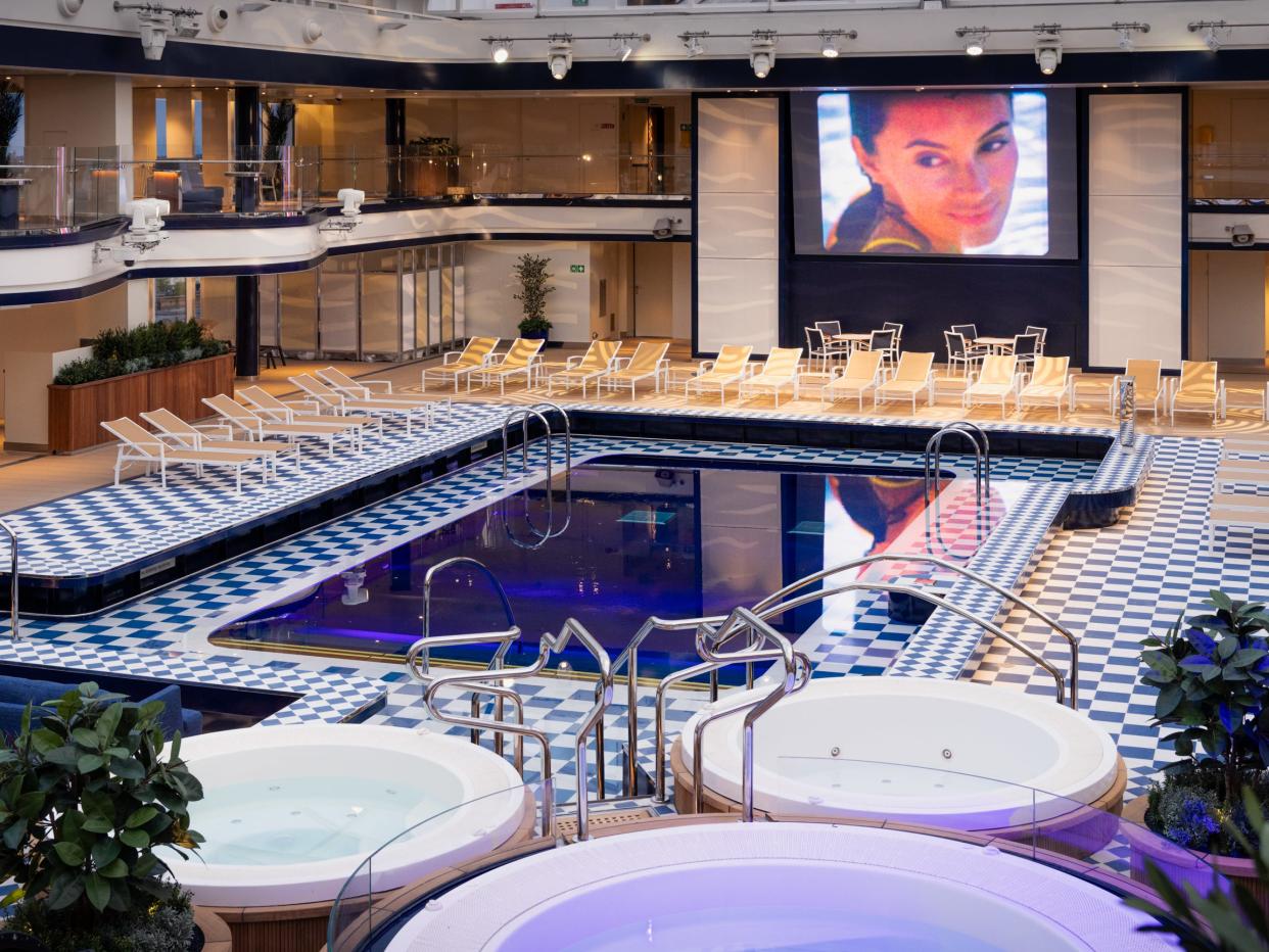 empty pool surrounded by chairs and a movie screen