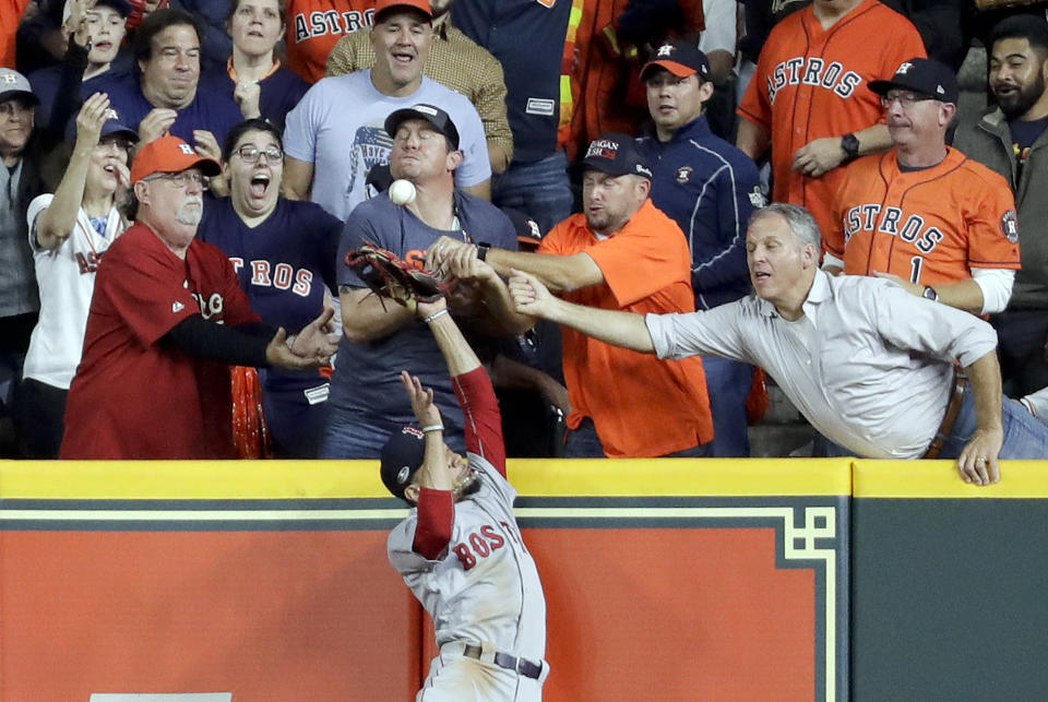 Fans interfere with Boston Red Sox right fielder Mookie Betts trying to catch a ball hit by Houston Astros' Jose Altuve during the first inning in Game 4 of a baseball American League Championship Series on Wednesday, Oct. 17, 2018, in Houston. Altuve was called out. (AP Photo/Frank Franklin II)