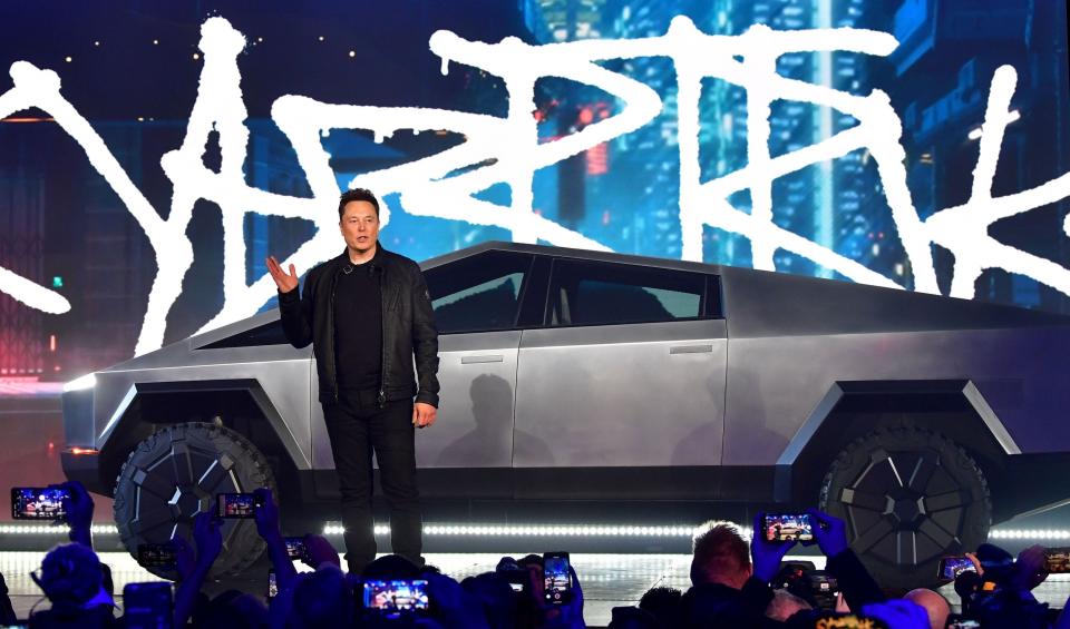 Tesla CEO Elon Musk stands in front of the company's Cybertruck.