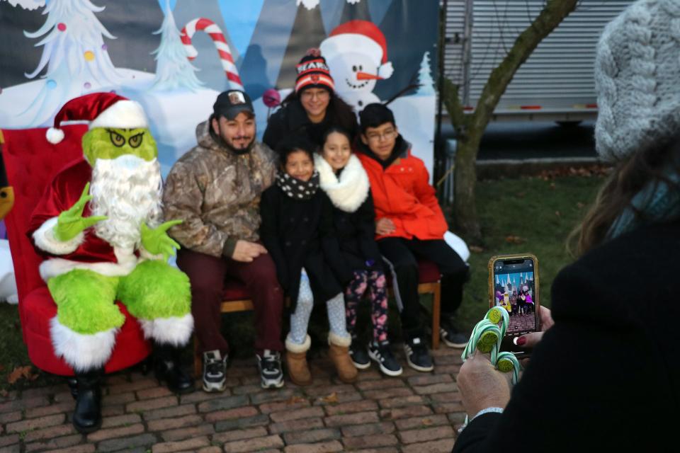 Families lined up to have their photos taken with the Grinch last year at Free Church Park as part of the "Dashing through Downtown" Christmas festivities.