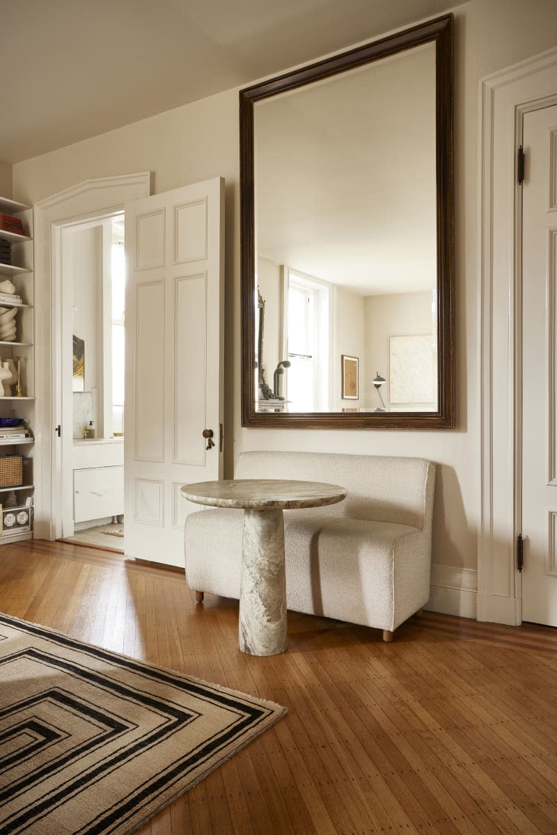 A large mirror and sitting area in a living room area.