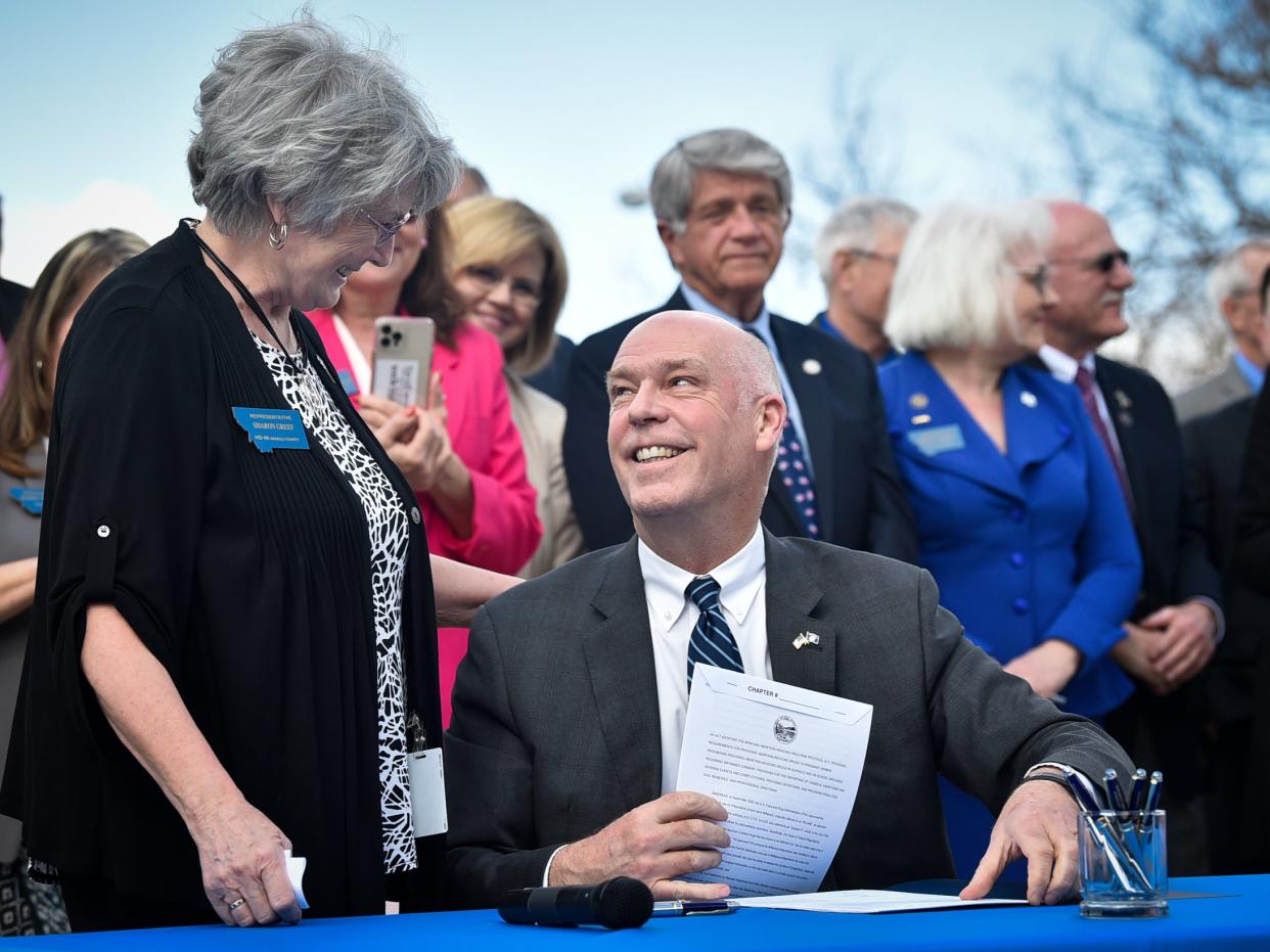 Republican Gov. Greg Gianforte smiles at Rep. Sharon Greef, R-Florence, during the signing of a bill in Helena, Mont. Monday, April 26, 2021.  (AP)
