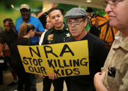 <p>A man with a sign is seen after the news conference in the hallway outside the courtroom where Nikolas Cruz appeared via video at a bond court hearing after being charged with 17 counts of premeditated murder, in Fort Lauderdale, Fla., Feb. 15, 2018. (Photo: Charles Trainor, jr./Pool/Reuters) </p>