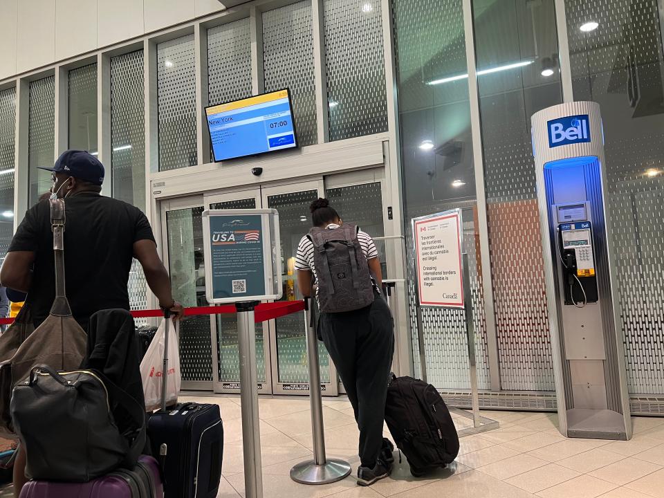 Greyhound bus passengers wait in line to depart from Montréal to New York City.