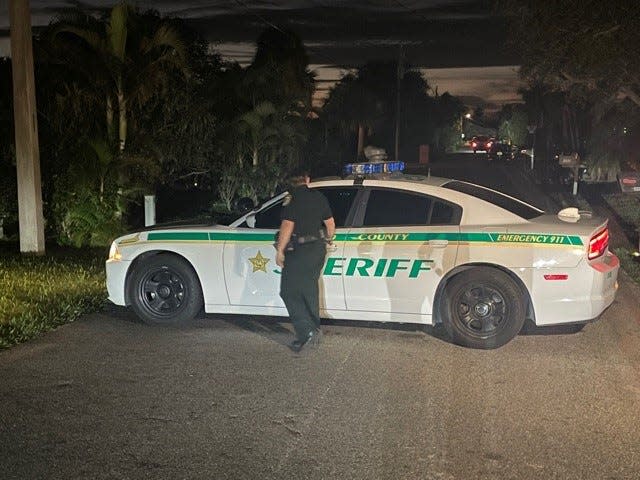 A Brevard County sheriff's deputy stands guard as crime scene agents, investigators go through house where an armed man confronted SWAT officers.