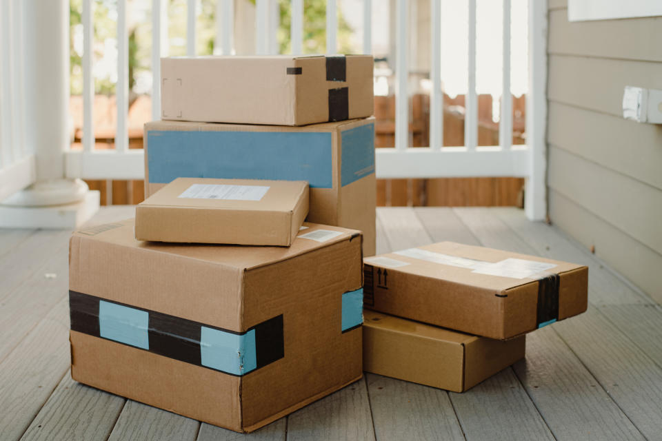 Stacked cardboard boxes on a porch, ready for delivery