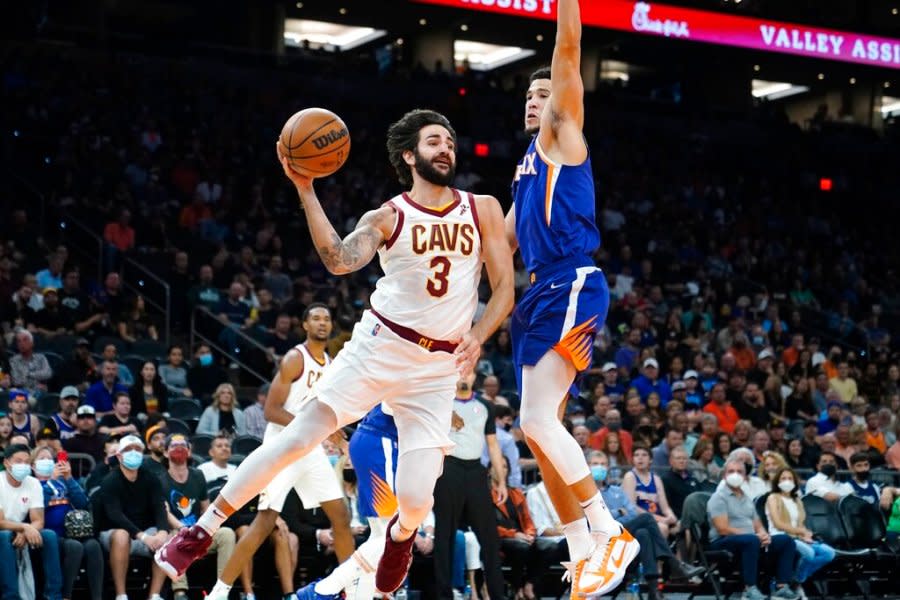 Cleveland Cavaliers guard Ricky Rubio (3) looks to pass the ball as Phoenix Suns guard Devin Booker defends during the first half of an NBA basketball game Saturday, Oct. 30, 2021, in Phoenix. (AP Photo/Ross D. Franklin)